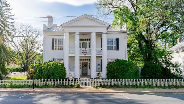 111 Main St S, Bridgewater, VA 22812 - neoclassical home featuring a porch, a fenced front yard, a balcony, and stucco siding