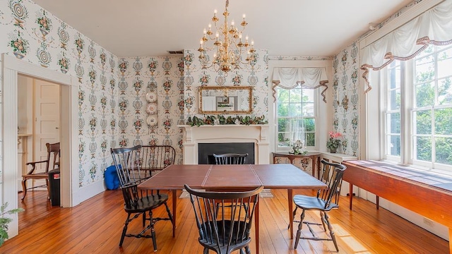 111 Main St S, Bridgewater, VA 22812 - dining space featuring wallpapered walls, light wood-style floors, a fireplace, a chandelier, and baseboards