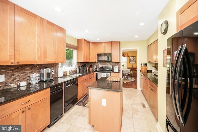 10415 Shaw Dr, Spotsylvania, VA 22553 - kitchen with black appliances, decorative backsplash, dark stone counters, a kitchen island, and light brown cabinets