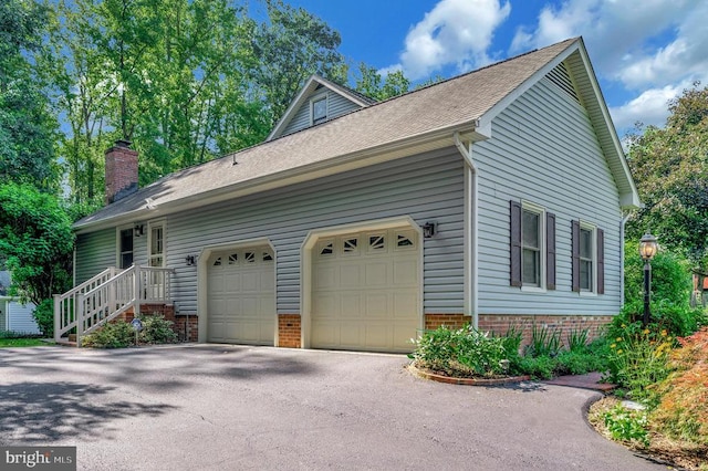 10415 Shaw Dr, Spotsylvania, VA 22553 - view of home's exterior featuring asphalt driveway, a chimney, brick siding, a garage, and roof with shingles