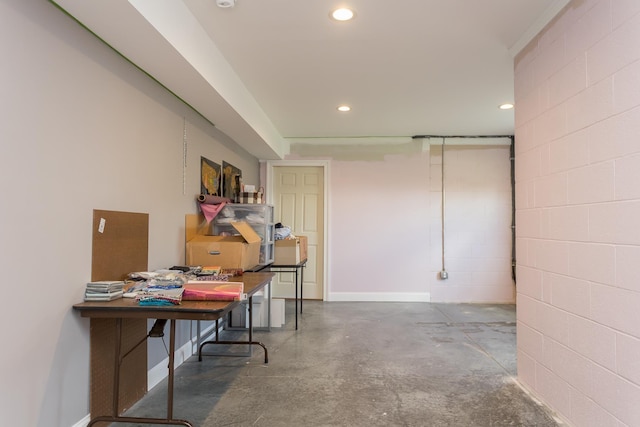 finished basement with concrete block wall, recessed lighting, and baseboards