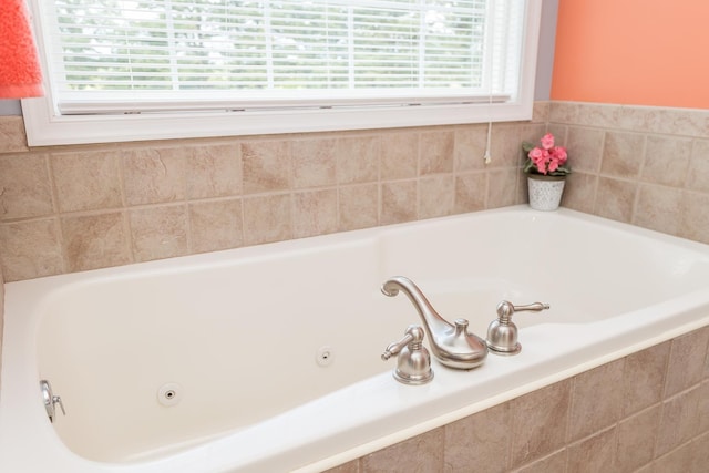 full bathroom with plenty of natural light and a tub with jets