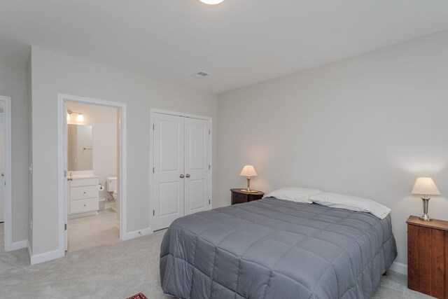 carpeted bedroom with connected bathroom and a closet