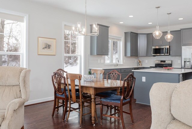 dining space featuring dark hardwood / wood-style floors, sink, and a chandelier