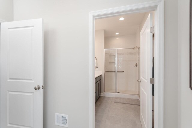 bathroom with vanity, tile patterned flooring, and a shower with door