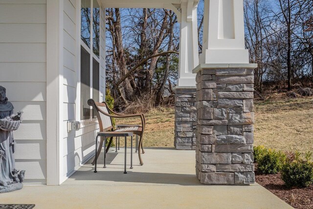 snow covered property entrance featuring a garage and covered porch