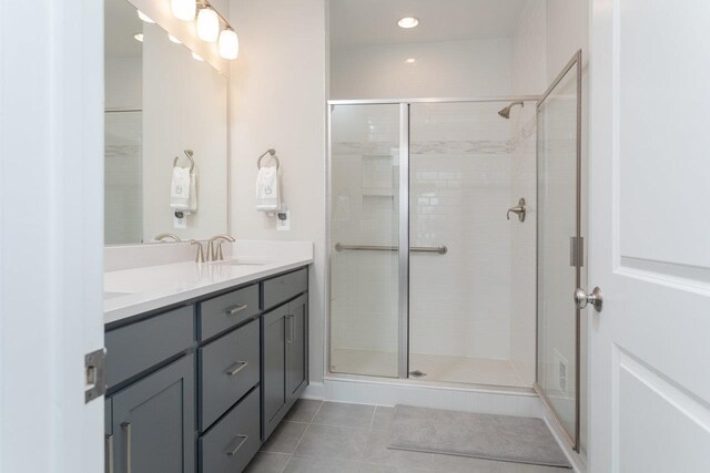 bathroom with walk in shower, tile patterned floors, and vanity