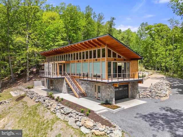 559 Bessie Bell Mountain Rd, Castleton, VA 22716 - view of front of home featuring stone siding, an attached garage, a deck, stairway, and driveway