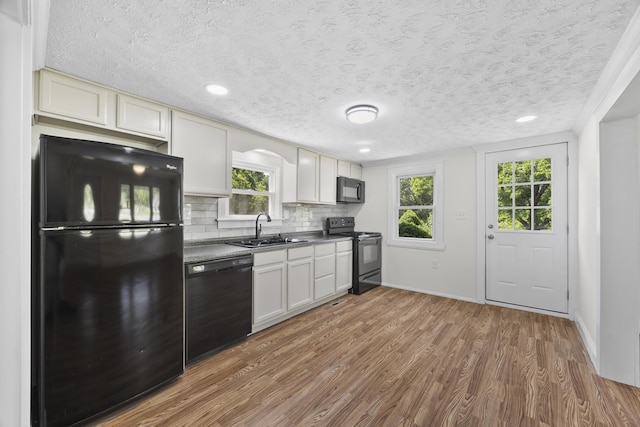 3416 Point Rd E, Elkton, VA 22827 - kitchen featuring black appliances, wood finished floors, decorative backsplash, plenty of natural light, and a textured ceiling