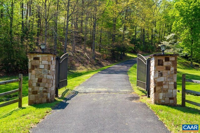 353 Bloomfield Rd, Charlottesville, VA 22901 - view of asphalt driveway featuring a gate, a gated entry, street lighting, and a forest view