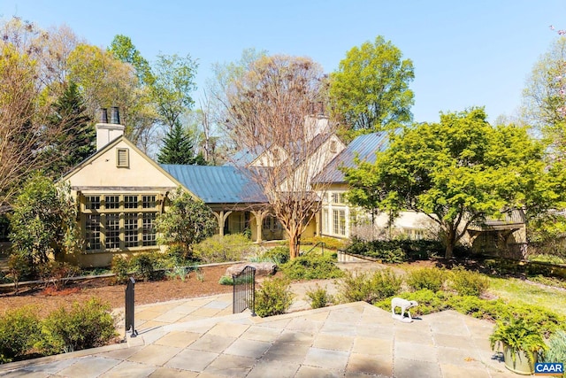 353 Bloomfield Rd, Charlottesville, VA 22901 - back of property featuring a patio, a chimney, metal roof, and stucco siding