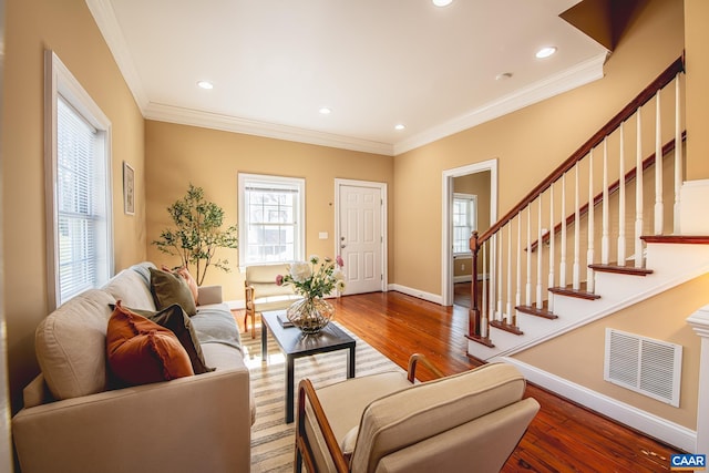 living room featuring recessed lighting, baseboards, ornamental molding, visible vents, and wood finished floors