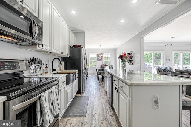 6905 Lakes Edge Way, Mineral, VA 23117 - kitchen with stainless steel appliances, a kitchen island, light wood finished floors, healthy amount of natural light, and recessed lighting