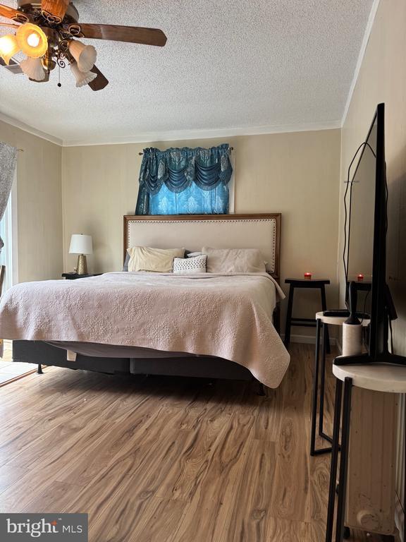 633 Ridge View Ln, Shenandoah, VA 22849 - bedroom featuring a textured ceiling, wood finished floors, ornamental molding, and ceiling fan