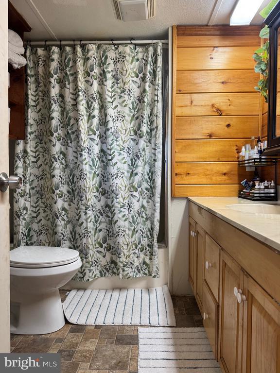 633 Ridge View Ln, Shenandoah, VA 22849 - bathroom featuring vanity, stone finish flooring, and shower / bathtub combination with curtain