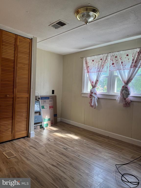 633 Ridge View Ln, Shenandoah, VA 22849 - unfurnished bedroom featuring wood finished floors, a closet, and a textured ceiling