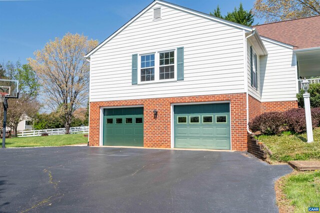 3340 Meadowfield Ln, Charlottesville, VA 22911 - garage featuring asphalt driveway and fence