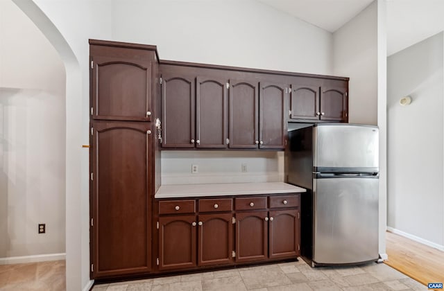 3340 Meadowfield Ln, Charlottesville, VA 22911 - kitchen with freestanding refrigerator, arched walkways, light countertops, baseboards, and dark brown cabinetry