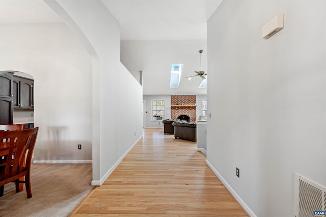 3340 Meadowfield Ln, Charlottesville, VA 22911 - hallway with high vaulted ceiling, arched walkways, baseboards, and light wood-style floors