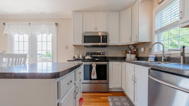 1411 Shenstone Dr, Harrisonburg, VA 22802 - kitchen featuring stainless steel appliances, tasteful backsplash, a center island, white cabinets, and crown molding