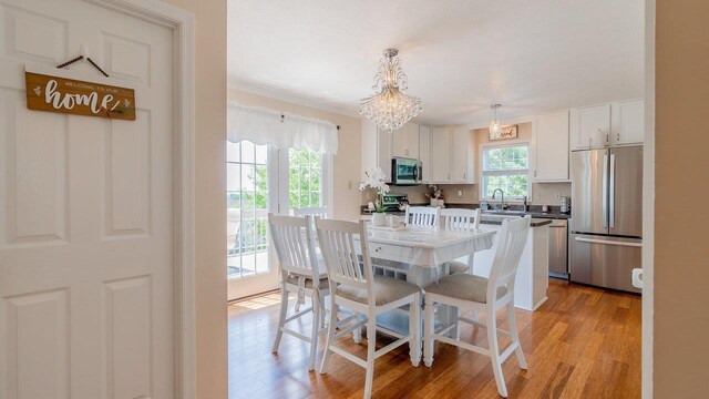 1411 Shenstone Dr, Harrisonburg, VA 22802 - dining space featuring light wood-style flooring, ornamental molding, and a chandelier