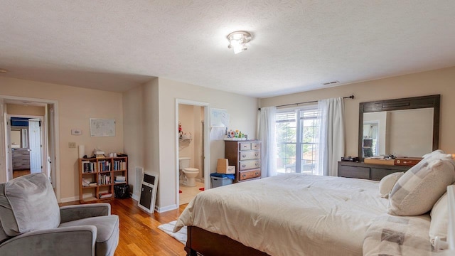 1411 Shenstone Dr, Harrisonburg, VA 22802 - bedroom featuring light wood finished floors, a textured ceiling, and connected bathroom