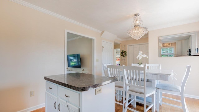 1411 Shenstone Dr, Harrisonburg, VA 22802 - kitchen with a chandelier, dark countertops, crown molding, white cabinetry, and light wood-style floors