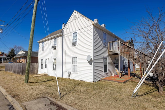 view of side of property with a patio, a yard, and cooling unit