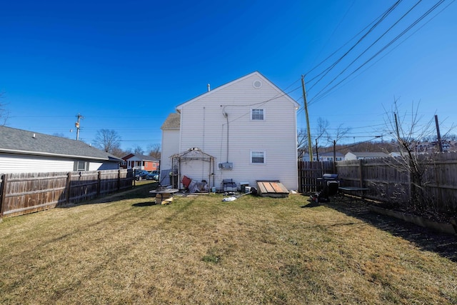 back of property featuring a lawn and a gazebo