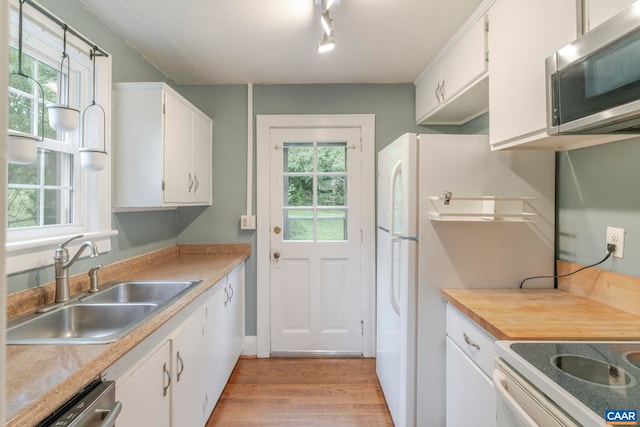 1014 Saint Charles Ave, Charlottesville, VA 22901 - kitchen with stainless steel microwave, white cabinets, light wood-style flooring, and plenty of natural light