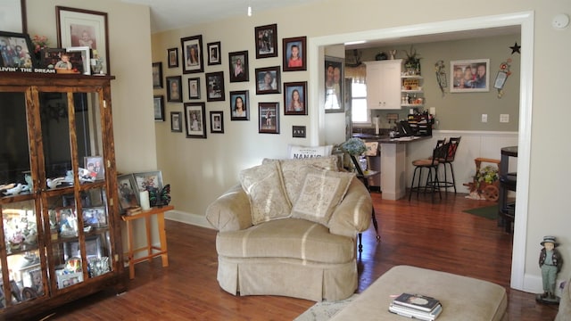 living area featuring wainscoting and wood finished floors