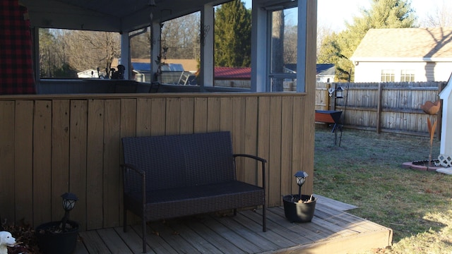 wooden terrace featuring a sunroom and fence