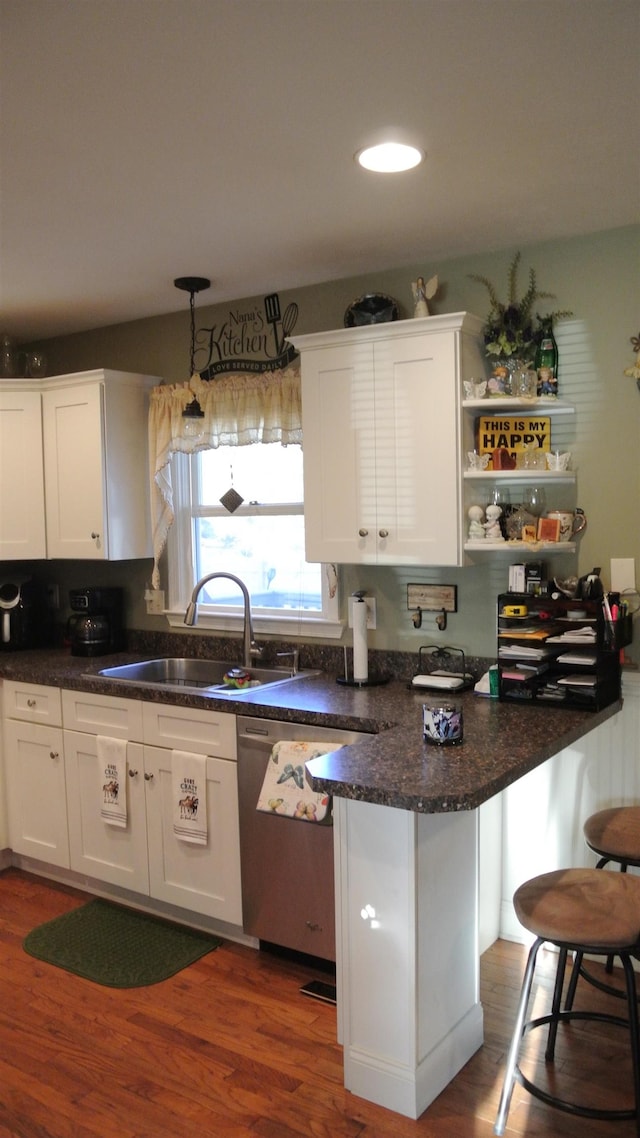 kitchen featuring dark wood-type flooring, white cabinets, and a sink