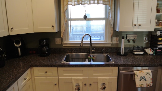 kitchen featuring dishwasher, a sink, and white cabinets