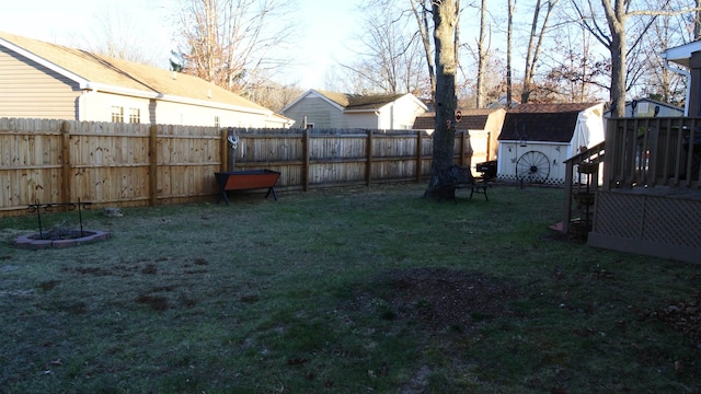 view of yard with a fenced backyard, an outdoor structure, and a storage shed