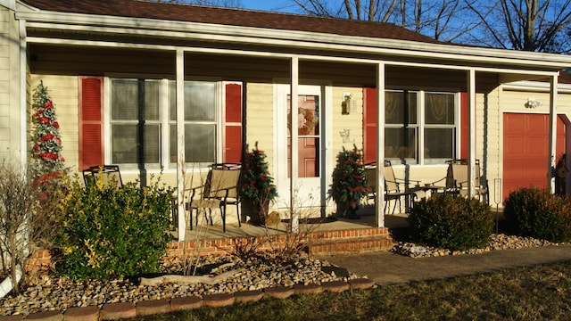 property entrance with a porch and roof with shingles