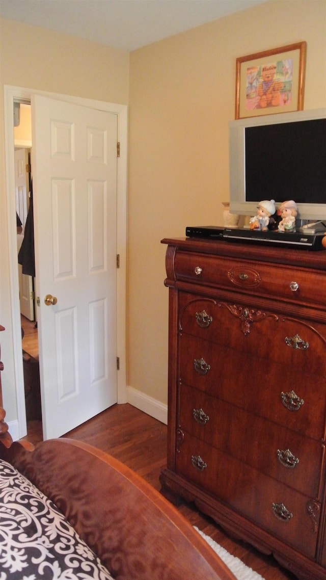 bedroom with dark wood finished floors and baseboards