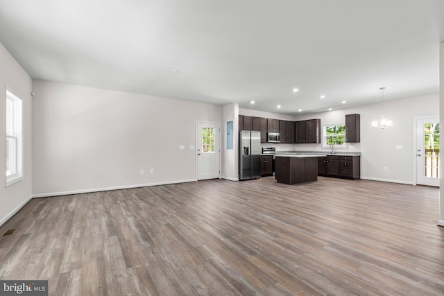 27000 Tatum Rd, Unionville, VA 22567 - unfurnished living room featuring wood finished floors, a chandelier, baseboards, recessed lighting, and a sink