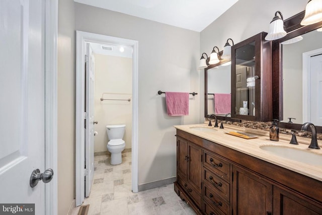 12203 Abner Ct, Fredericksburg, VA 22407 - bathroom featuring double vanity, baseboards, and toilet