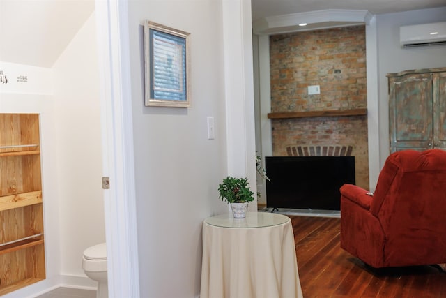 interior space featuring dark wood finished floors, a fireplace, and an AC wall unit