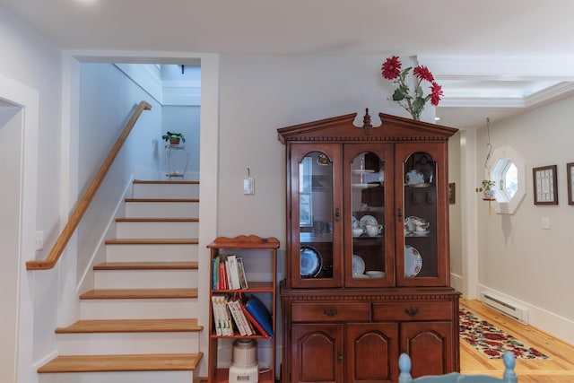 stairs with baseboard heating and wood finished floors