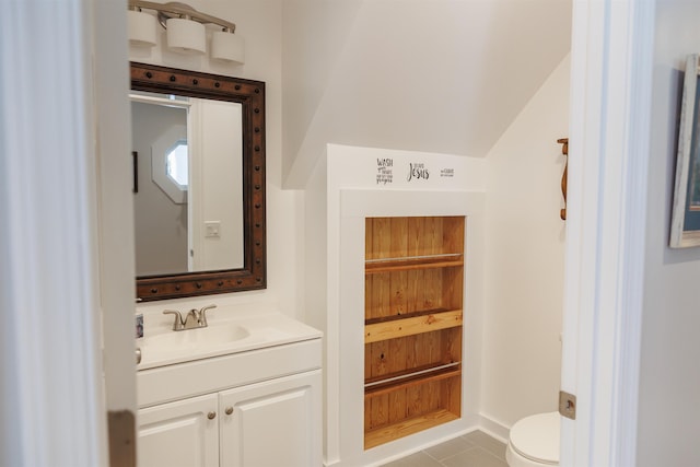 half bathroom with vanity, toilet, and tile patterned flooring