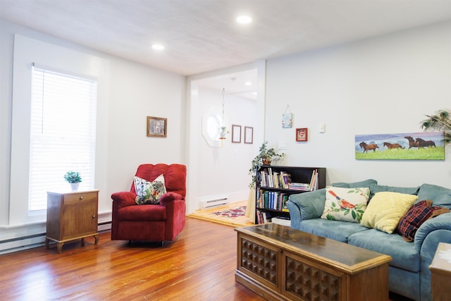 living area with recessed lighting, wood-type flooring, and a baseboard heating unit