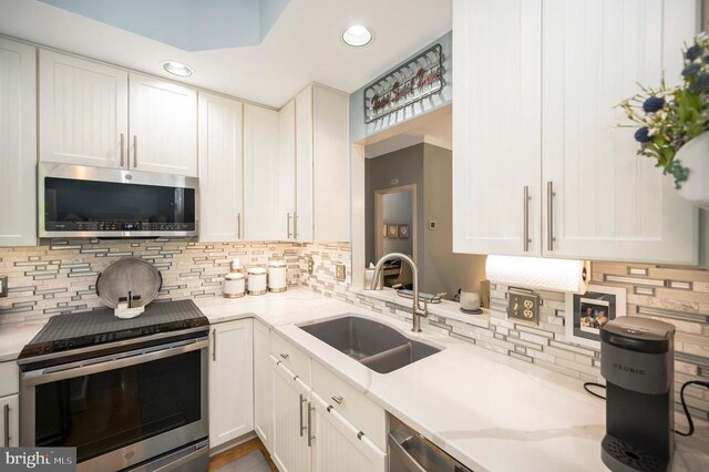 9404 Dalmahoy Ln, Fredericksburg, VA 22408 - kitchen with appliances with stainless steel finishes, a sink, tasteful backsplash, white cabinets, and recessed lighting