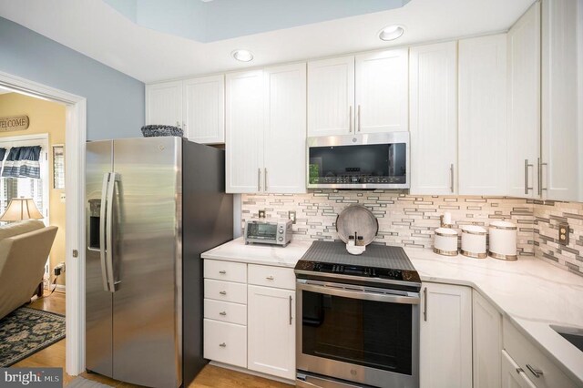 9404 Dalmahoy Ln, Fredericksburg, VA 22408 - kitchen with stainless steel appliances, backsplash, white cabinetry, and recessed lighting