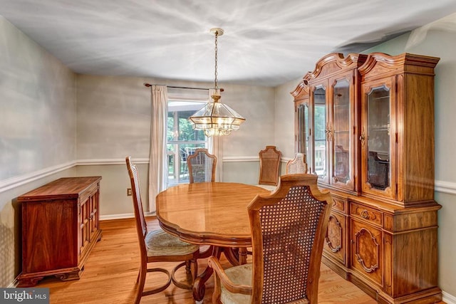  - dining area with a chandelier and light wood finished floors