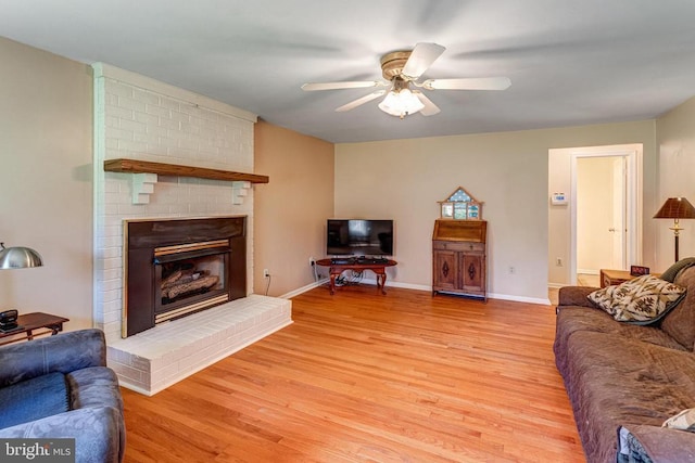  - living room with light wood-style flooring, ceiling fan, and a fireplace
