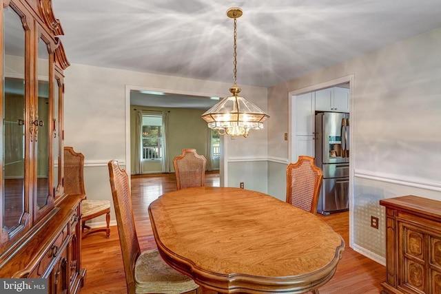  - dining space featuring a chandelier and wood finished floors