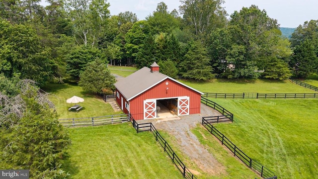  - view of barn with an exterior structure, dirt driveway, and a lawn