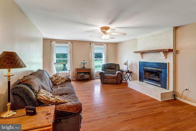  - living room with a brick fireplace, wood finished floors, and a ceiling fan